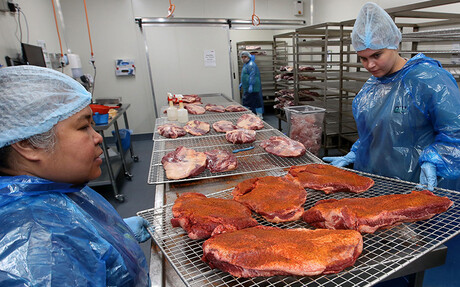 Applying the rub to the meat at Texas BBQ Foods